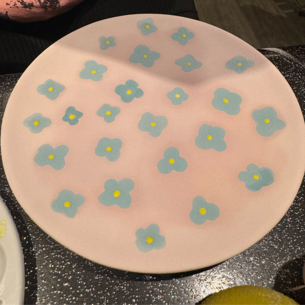 Pink plate with painted blue flowers on 